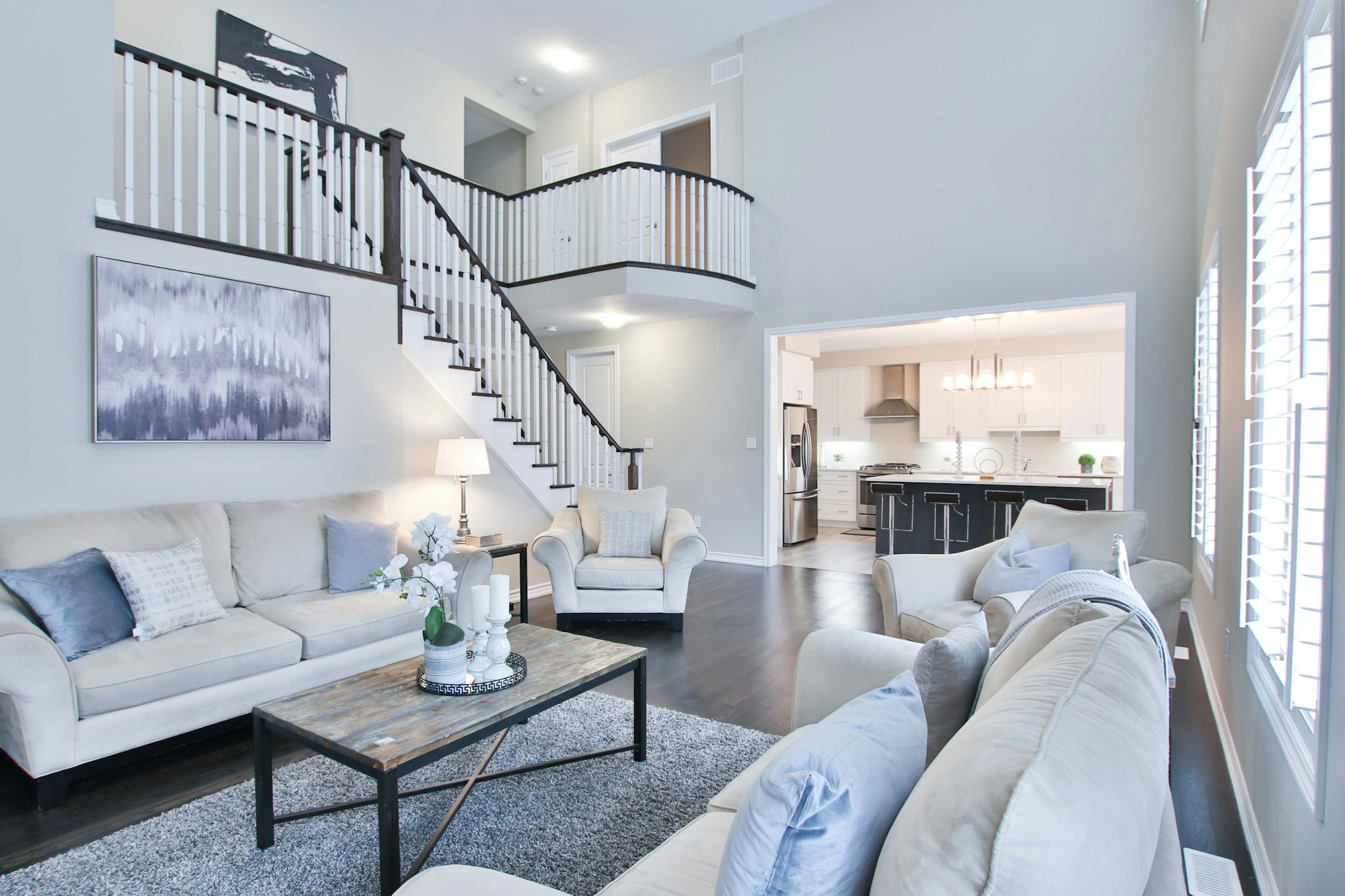 Living room with hardwood floors, open stair, and the master loft above.