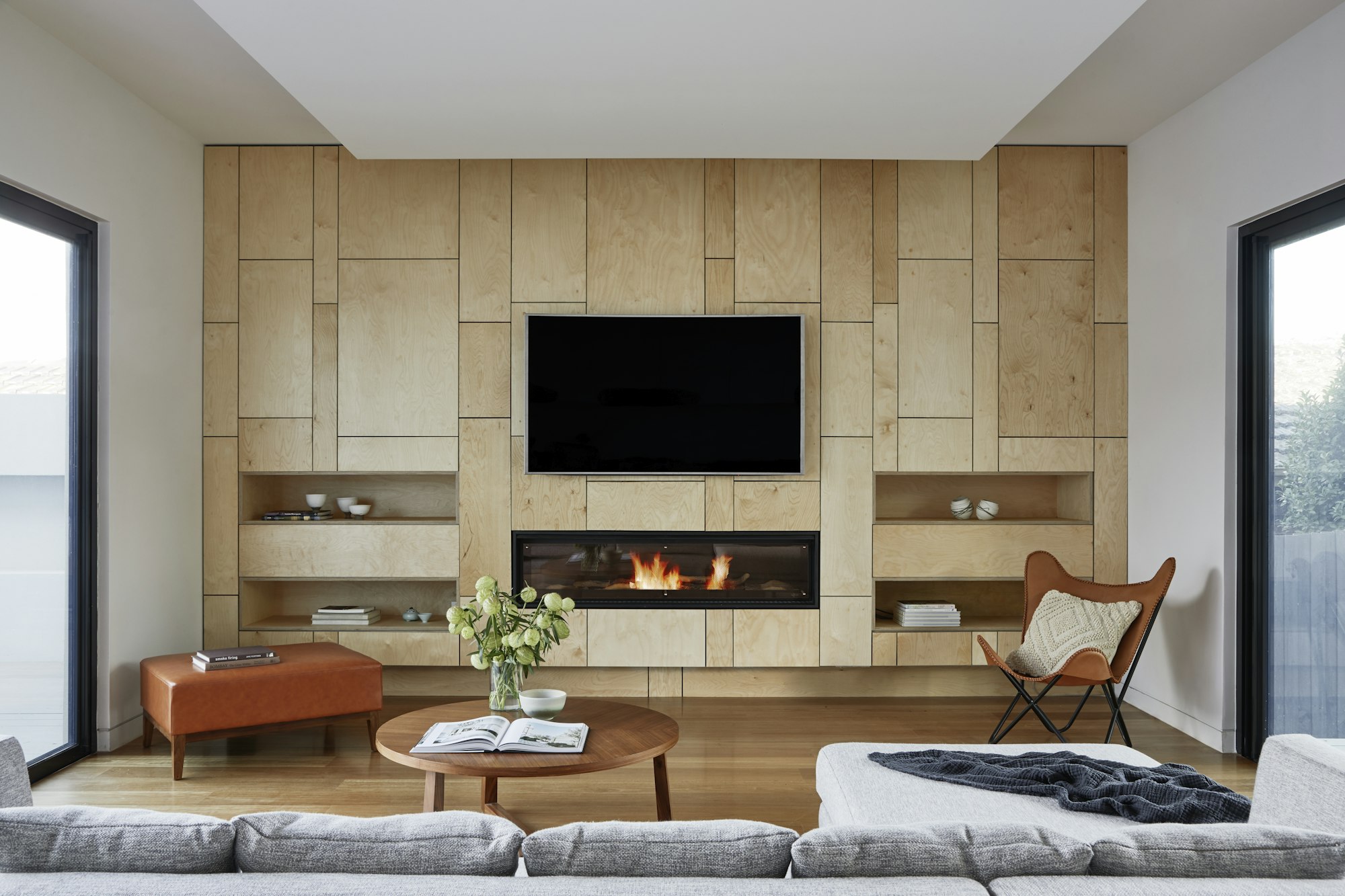 Main living room anchored by a gas fireplace set into a wood-paneled wall.
